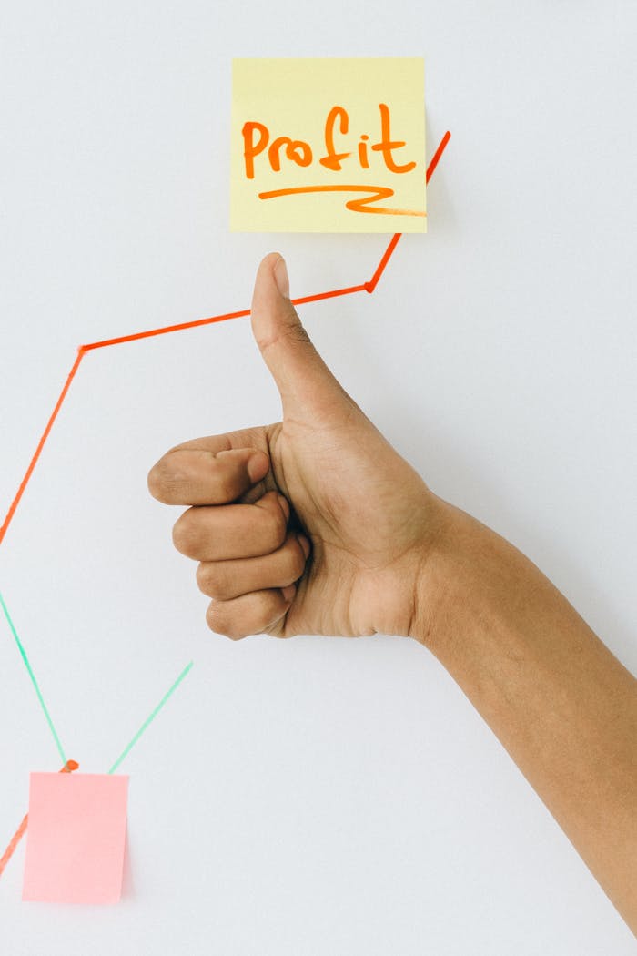 hero-img-02 A hand giving a thumbs up in front of a profit growth chart, highlighting success.